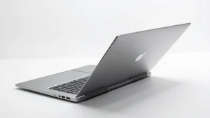 Sleek aluminum laptop with precision-cut cooling vents, open at 45-degree angle showing premium keyboard and trackpad, studio lighting highlighting metallic finish and minimalist design