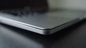 High-resolution close-up of premium aluminum laptop chassis with chamfered edges, matte finish, minimalist design, professional photography lighting