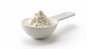 Close-up of white crystalline creatine monohydrate powder in a clear measuring scoop against white background, professional supplement photography