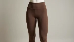 Brown Nike Tech pants displayed on mannequin showing full fit from waist to ankles, neutral background, natural lighting highlighting fabric drape and tapered silhouette