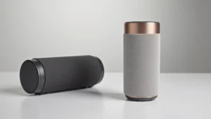 Premium portable Bluetooth speaker with cylindrical design, rubberized grip texture, metallic accents, modern minimalist aesthetic, professional product photography with studio lighting and neutral background